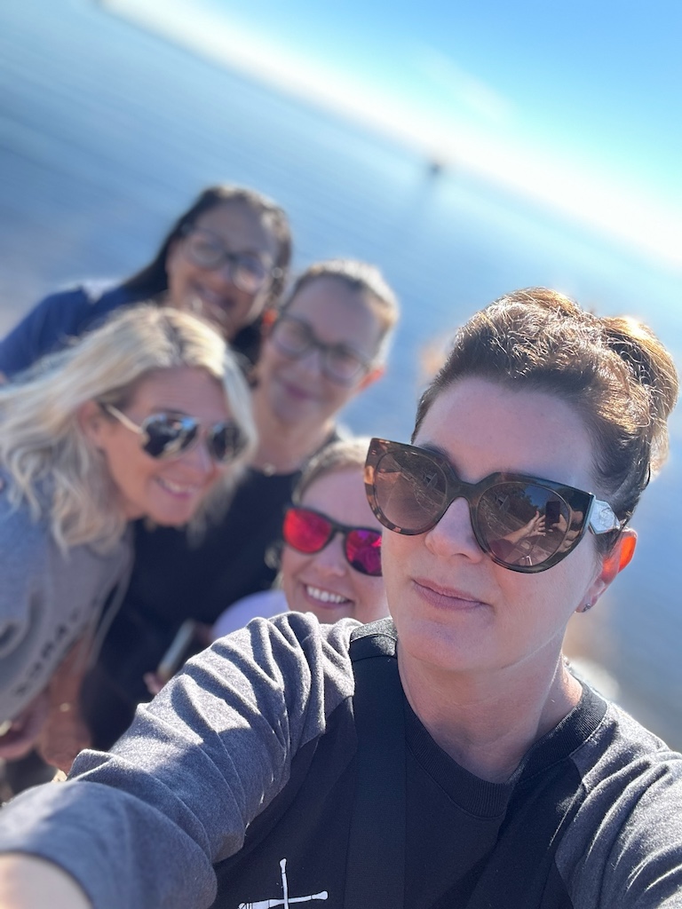 A group of women pose for a selfie on a camping trip.